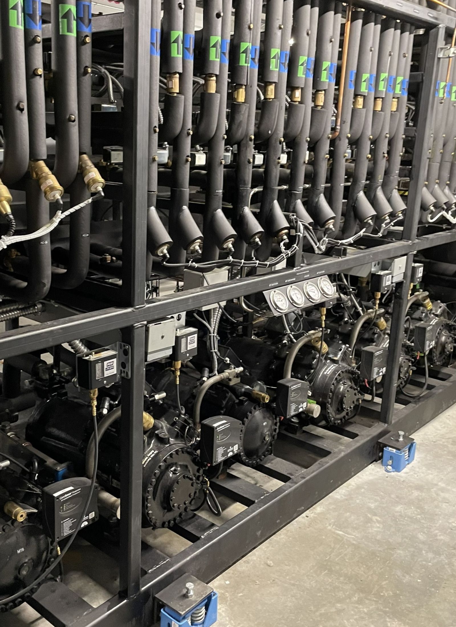 Close-up of a CO2 refrigeration rack system showing pipes and gauges